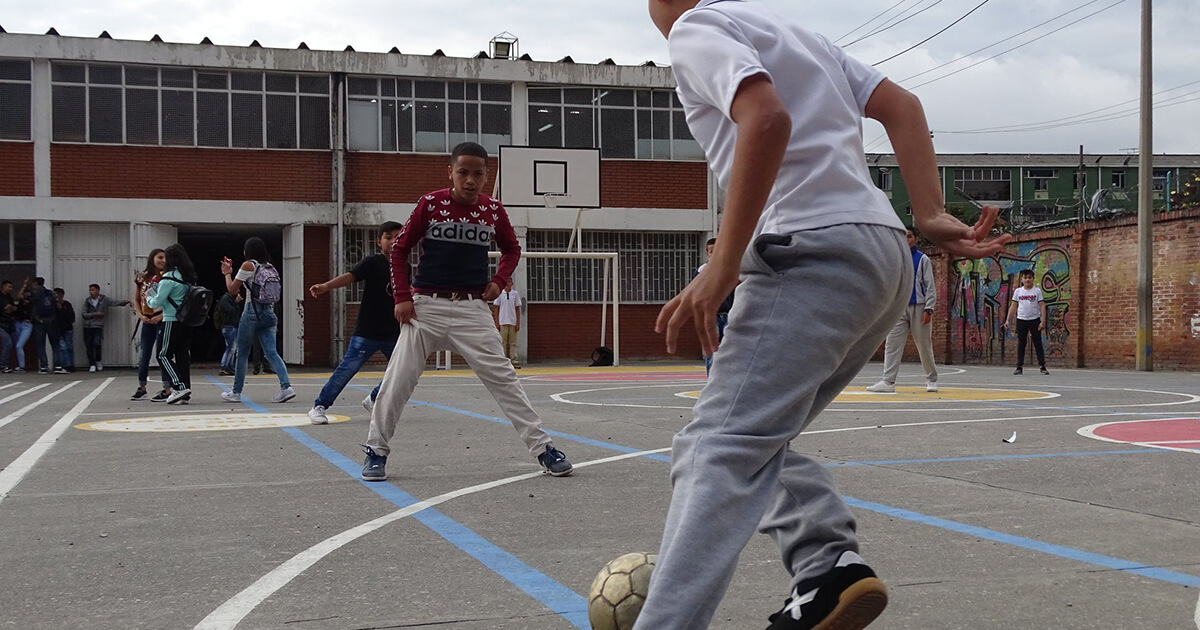 Niños jugando fútbol en el colegio