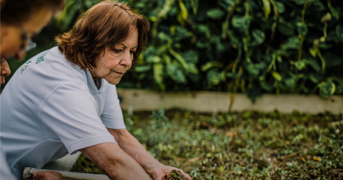 Una mujer plantando café en los cultivos de la federación de cafeteros.